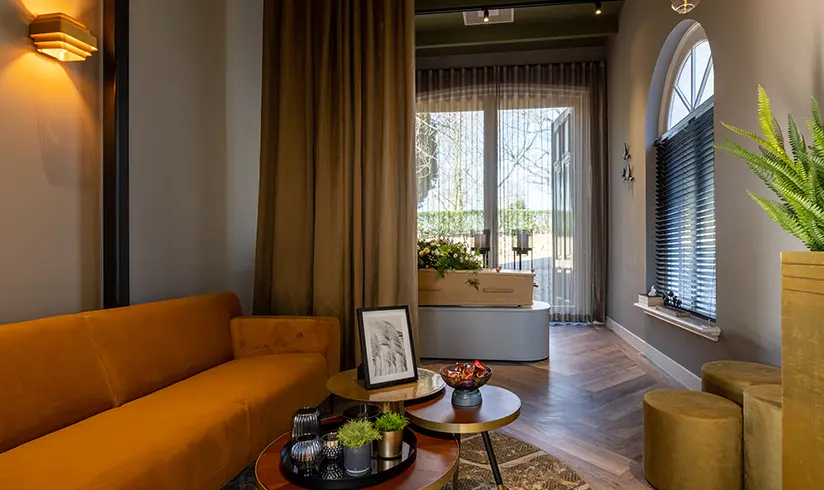 Moderne kamer met een bank en achterin een kist met bloemen